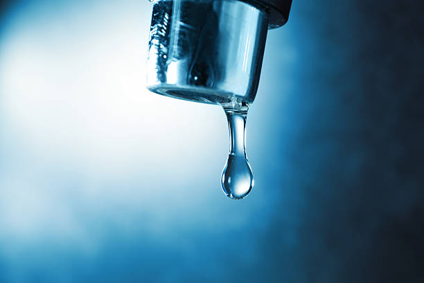 istock Water dripping down from faucet on color background, closeup 2252359673