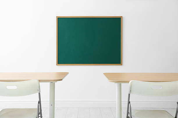 istock Blank green chalkboard, desks and chairs in classroom 2252362175