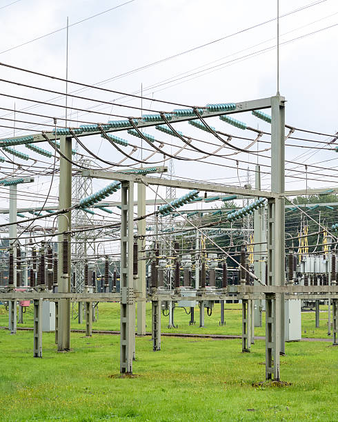 istock Power distribution station surrounded by green grass and high voltage lines on a cloudy day 2252363755