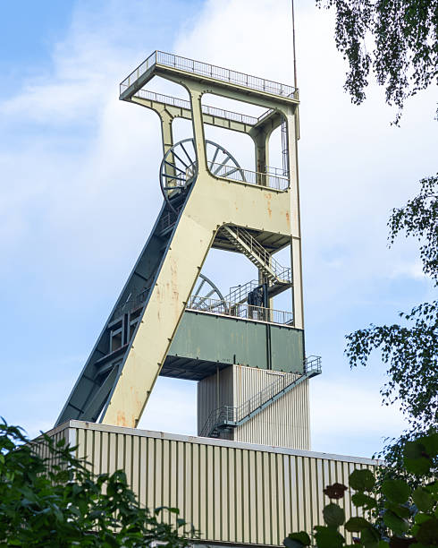 istock Old coal mine tower stands against a blue sky with clouds in a peaceful setting 2252363757