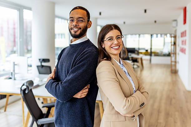 istock Confident Business Partners Stand Back-To-Back in a Modern Open-Plan Office 2252365213