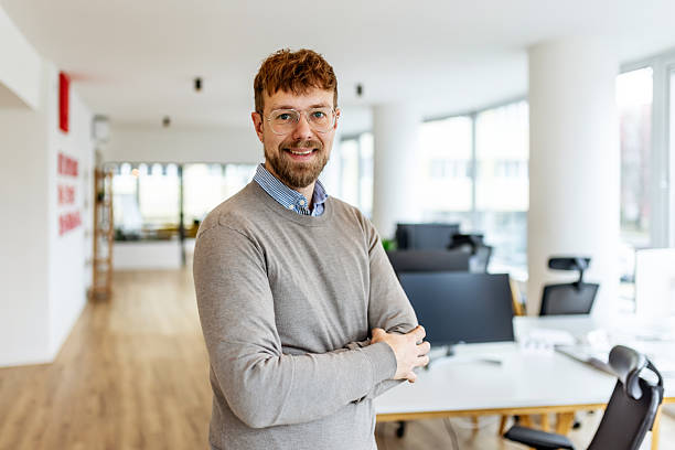 istock Confident Office Professional With Glasses Standing Smiling In Modern Open Plan Workspace 2252365264