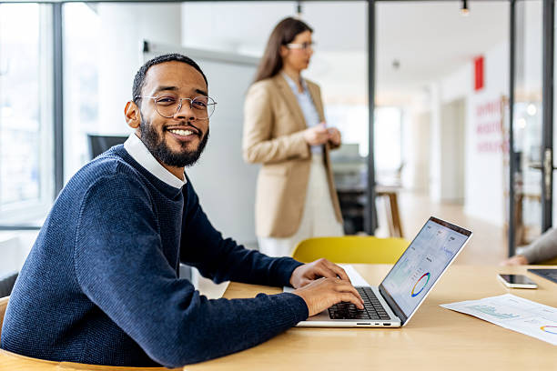 istock Friendly Business Professional Working on Laptop in Modern Office with Colleagues 2252365436