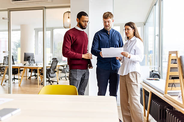 istock Colleagues Review Documents During a Collaborative Meeting in a Modern Open-Plan Office 2252366232