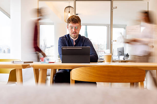 istock Focused Professional Working At Tablet In Bright Modern Office With Blurred Colleagues 2252366865
