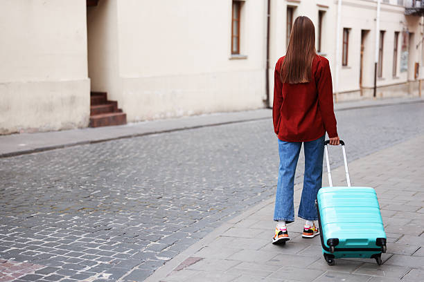 istock Goodbye. Woman with luggage walking outdoors, back view. Space for text 2252367028