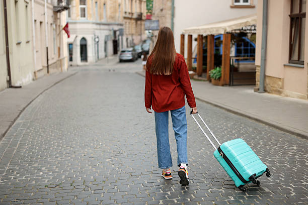 istock Goodbye. Woman with luggage walking outdoors, back view. Space for text 2252367462