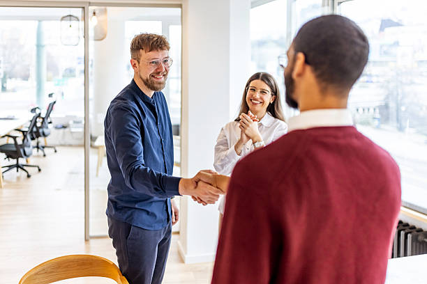 istock Handshake Between Colleagues In A Modern Office With Smiling Coworkers Celebrating Collaboration 2252368344