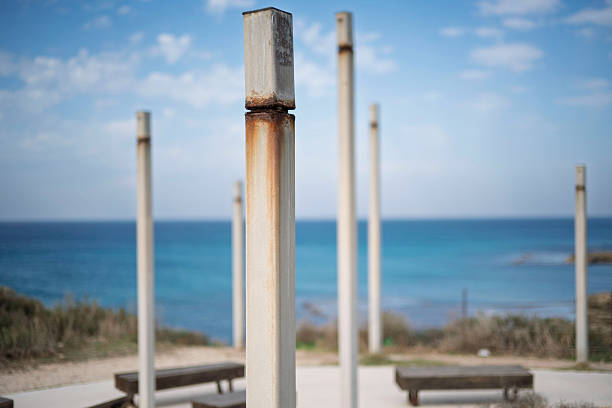 istock Weathered metal posts stand guard over a serene blue ocean horizon with scattered clouds 2252370034