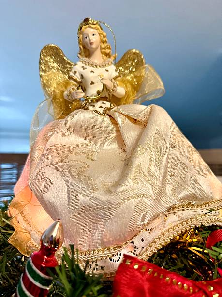 Christmas angels and balls with weaving on the background of a Christmas tree, handmade decor in an eco-style, hands close-up, top view