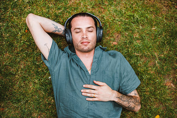 istock Mature Caucasian Non-Binary Person Relaxing in Park with Guided Meditation 2252373614