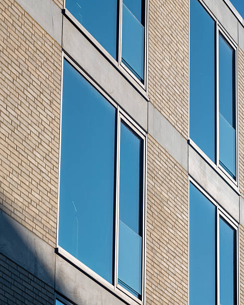 istock Modern building facade with large windows reflecting clear blue sky during daylight 2252374357