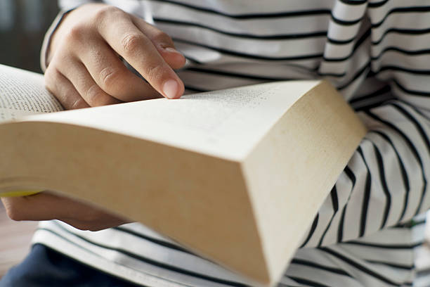 istock Hands Gripping Yellow Book for Leisure or Study 2252377119