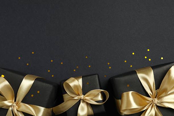 istock Beautiful gift boxes with a golden bows on black background 2252381734