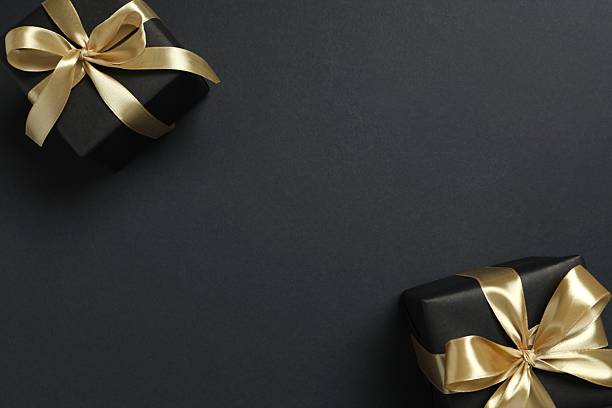 istock Beautiful gift boxes with a golden bows on black background 2252381738