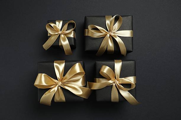 istock Beautiful gift boxes with a golden bows on black background 2252381761