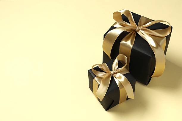 istock Beautiful gift box with a golden bow on beige background 2252383553