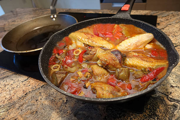 istock Chicken, squid and seafood simmering in a vegetable-based broth in a cast iron casserole dish. 2252384204