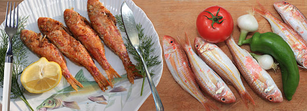 Female chef shows sea bream fish with lemon, parsley,garlic.
