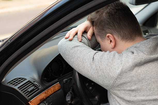 istock Young driver leaning forward on the steering wheel inside a car 2252386577