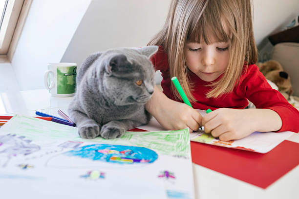 istock Boy creating art at home with curious cat 2252387475