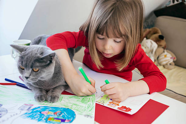 istock Child drawing at home with cat companion 2252387480
