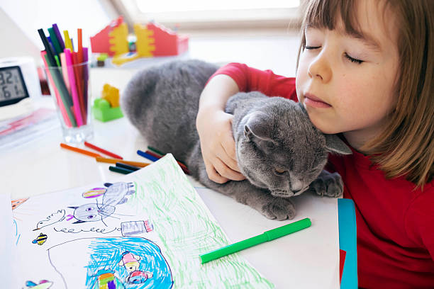 istock Child hugging his cat while drawing at home 2252387483