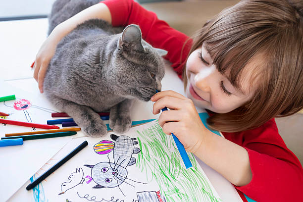 istock Child and playful cat sharing drawing time 2252387502