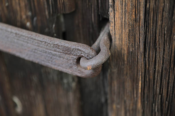 Close-Up Detail Of A Rusty Metal Hook Fastened To An Aged Wooden Surface, Showing Weathered Texture And Natural Decay.