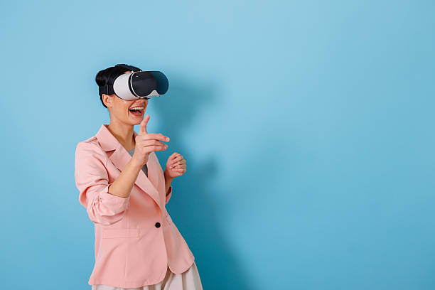 istock Woman wearing virtual reality headset pointing hand in metaverse experiencing future technology 2252391724