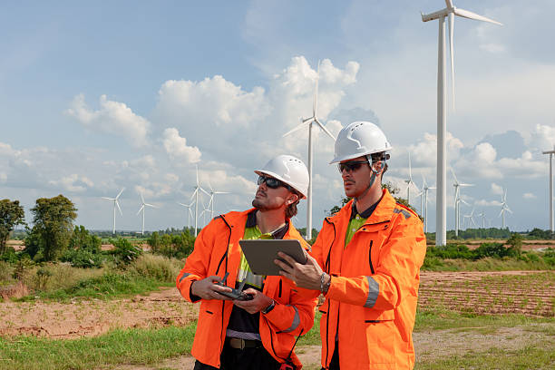 istock Engineers reviewing turbine data on tablet outdoor wind farm field drone controller actions during maintenance project teamwork working green energy technology renewable power future generation 2252392520