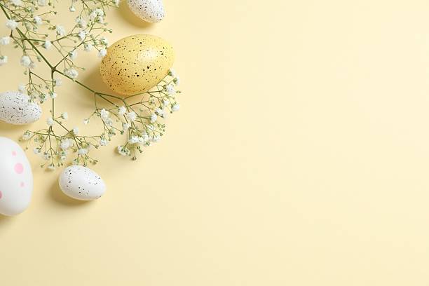 istock Happy Easter. Colorful eggs and white spring flowers on color background, space for text or advertising 2252394099