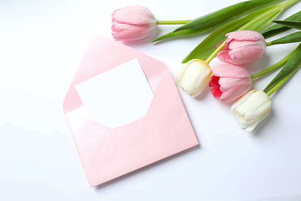 istock Beautiful fresh tulips with paper envelope on white background 2252397757