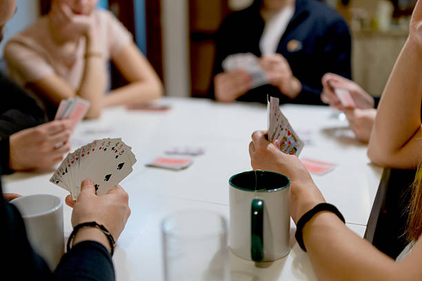 istock Close Up of Playing Cards on Table with Human Hands 2252406203