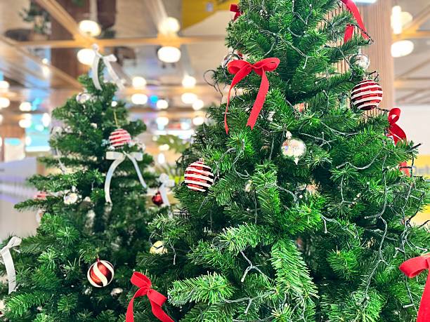 istock Artificial Christmas trees with decorations such as balls, red bows, and lights. 2252411203