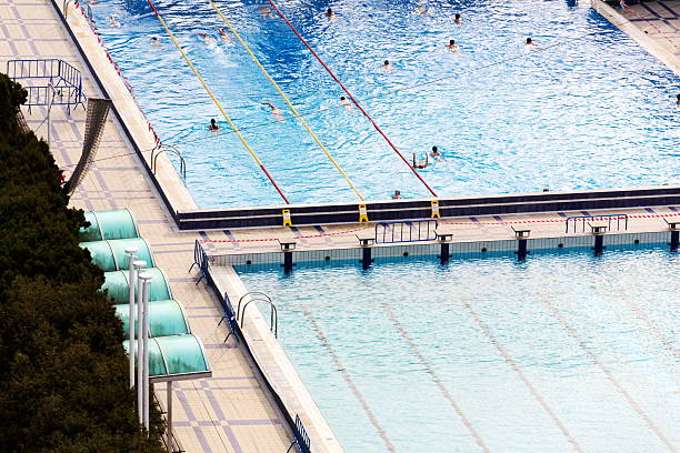Unrecognizable people swimming in beautiful outdoors public pool, Podoli swimming complex, Prague, Czech republic
