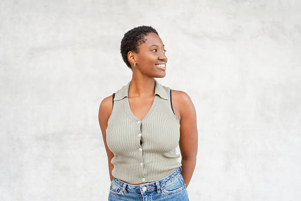 istock Smiling thoughtful woman looking away standing against wall 2252414591