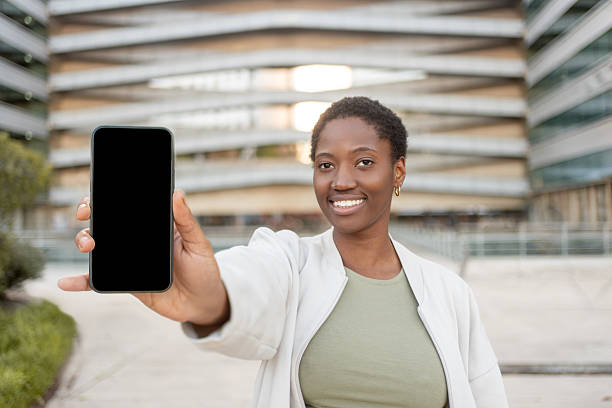 istock Smiling woman showing smartphone with empty screen for mockup 2252414603