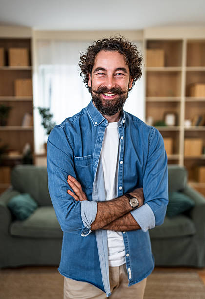 istock Smiling man with beard standing confidently at home 2252416456