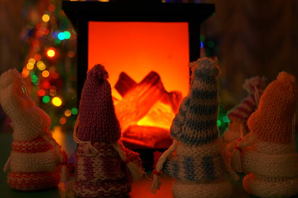 Toy angels warming themselves by the fireplace