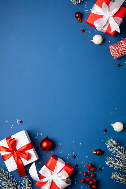 istock Red and white Christmas decorations and gifts on blue background. 2252420895