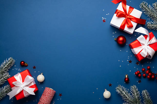 istock Red and white Christmas decorations and gifts on blue background. 2252420896