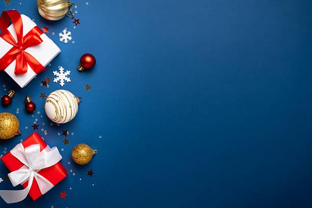 istock Red and white Christmas decorations and gifts on blue background. 2252420937
