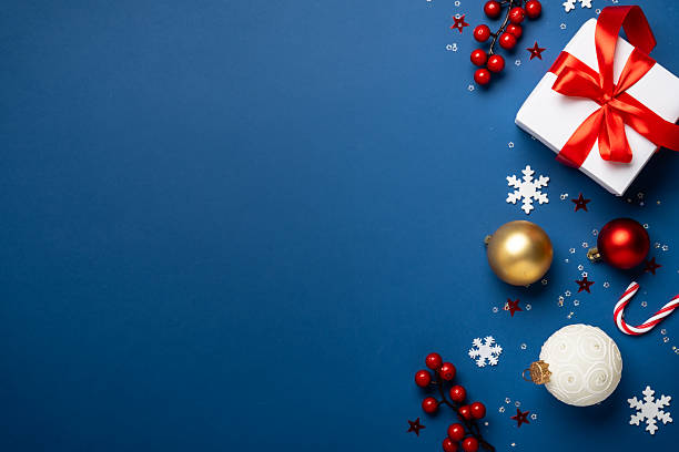 istock Red and white Christmas decorations and gifts on blue background. 2252420938