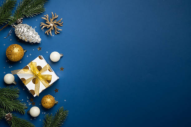 istock White and golden Christmas decorations and gift box on navy background. 2252421016
