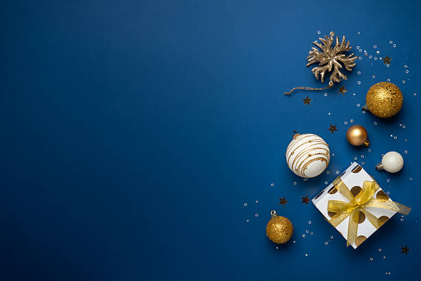 istock White and golden Christmas decorations and gift box on navy background. 2252421018
