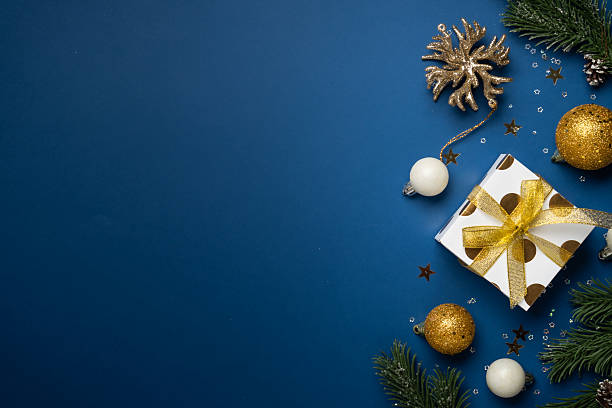 istock White and golden Christmas decorations and gift box on navy background. 2252421028