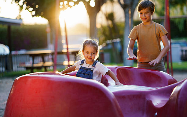 istock Children playing on playground carousel at sunset. 2252424424
