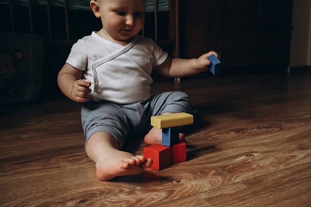 istock Baby Stacking Colorful Blocks on Wooden Floor 2252425198