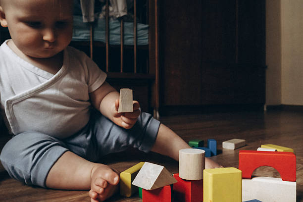 istock Baby Stacking Colorful Blocks on Wooden Floor 2252425273